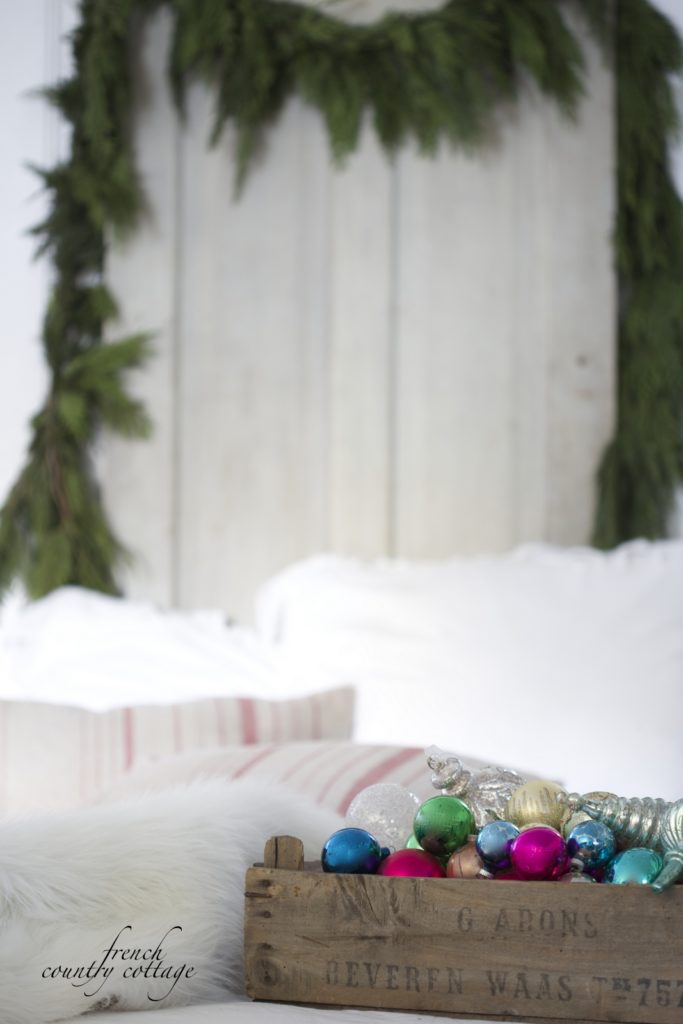 Fresh Garland on bed with ornaments in wooden crate