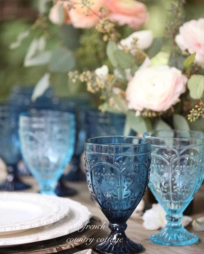 Blue goblets with flowers on table