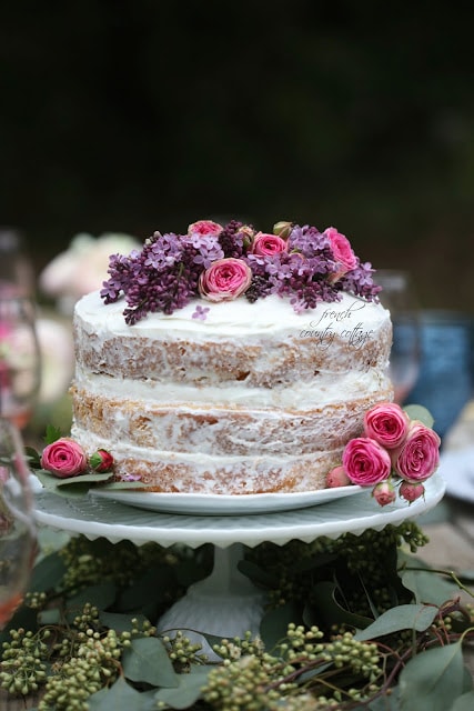 Rustic naked cake topped with lilac and rose flowers