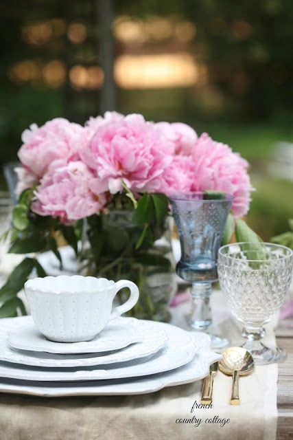 romantic table setting with white dishes outdoors