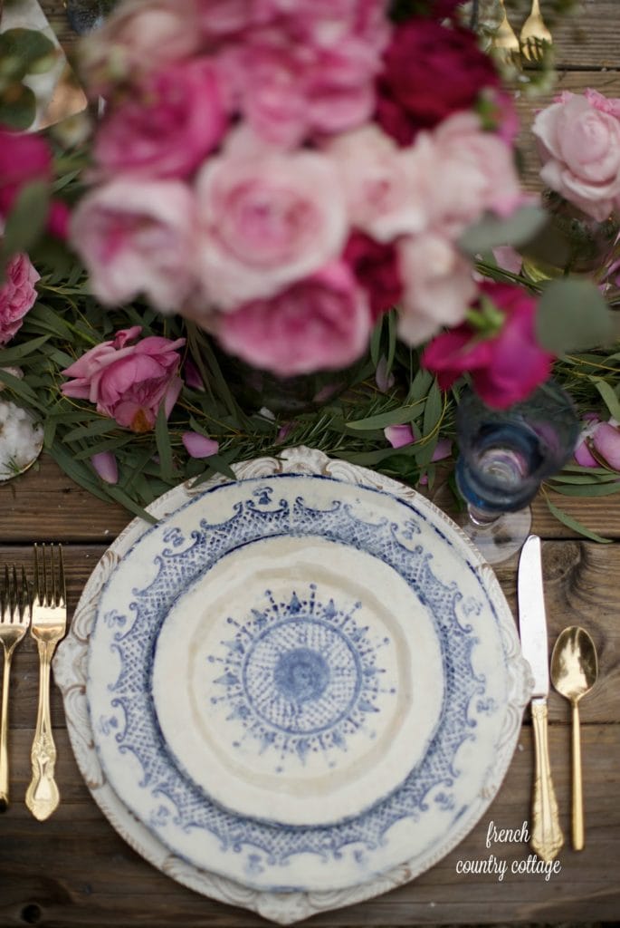 Table setting with blue and white dishes and pink flowers