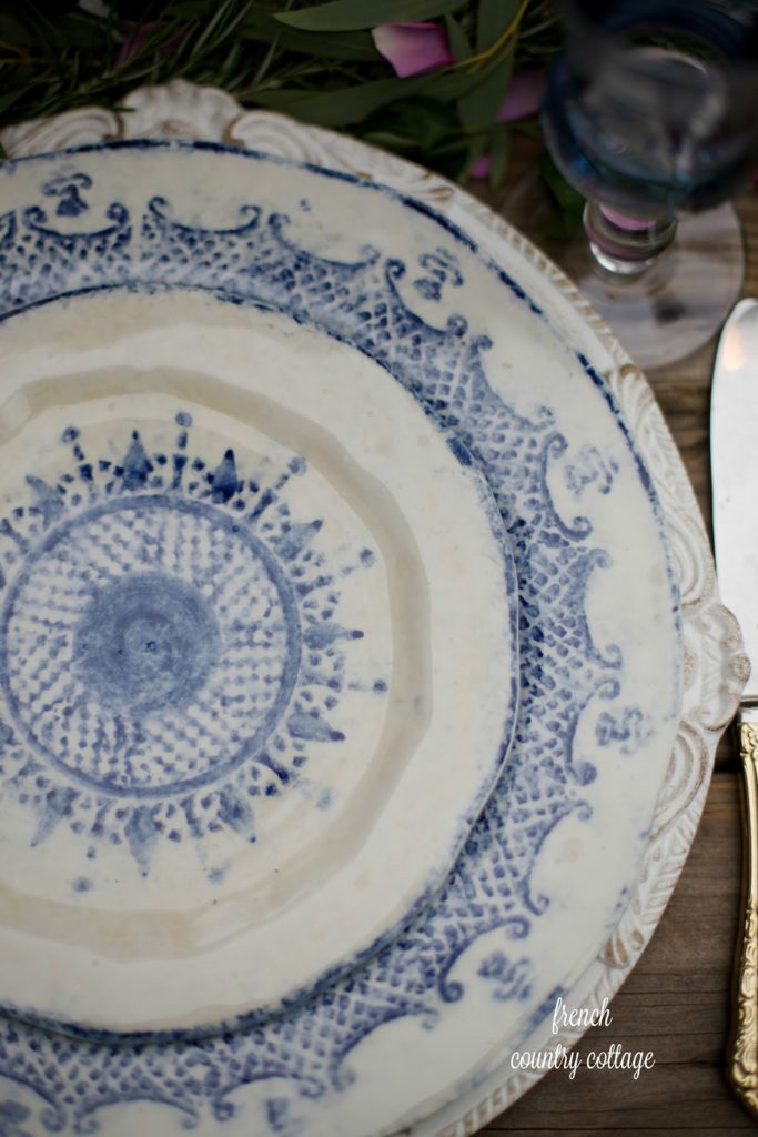 Blue and white hand painted dishes on carved chargers table setting