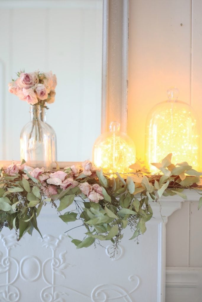 blooms and twinkle lights on mantel
